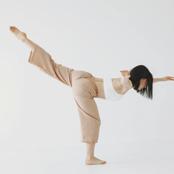 Side view of a woman performing a stretching yoga exercise.